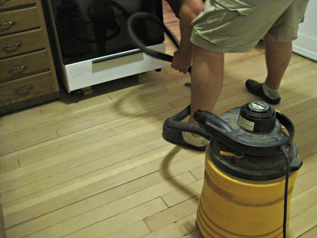 The first step in prepping a hardwood floor to varnish is making sure to clear away any debris | Refinishing Hardwood Floors man vacuum hardwood floor shop vac