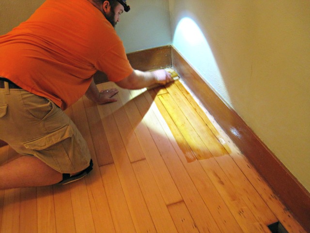 Applying varnish to the hardwood floor with a lambswool applicator | Refinishing hardwood floors man applying varnish hardwood floor applicator